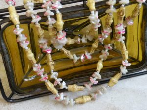 Vintage garland made with bamboo and nut pieces between red white pearlescent sea shell pieces.