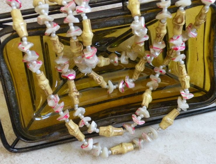 Vintage garland made with bamboo and nut pieces between red white pearlescent sea shell pieces.