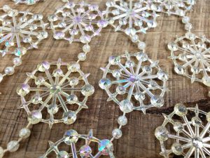 Clear plastic snowflake garland with a rainbow sheen.
