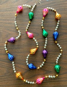 Vintage garland with white and gold beads between large, colorful, teardrop-shaped glass beads.