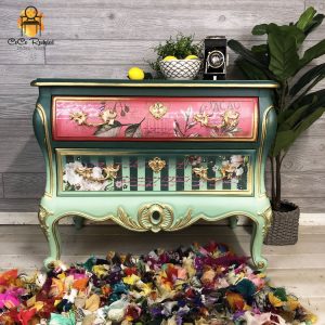 Light green and pink painted dresser with stripe and floral designs.