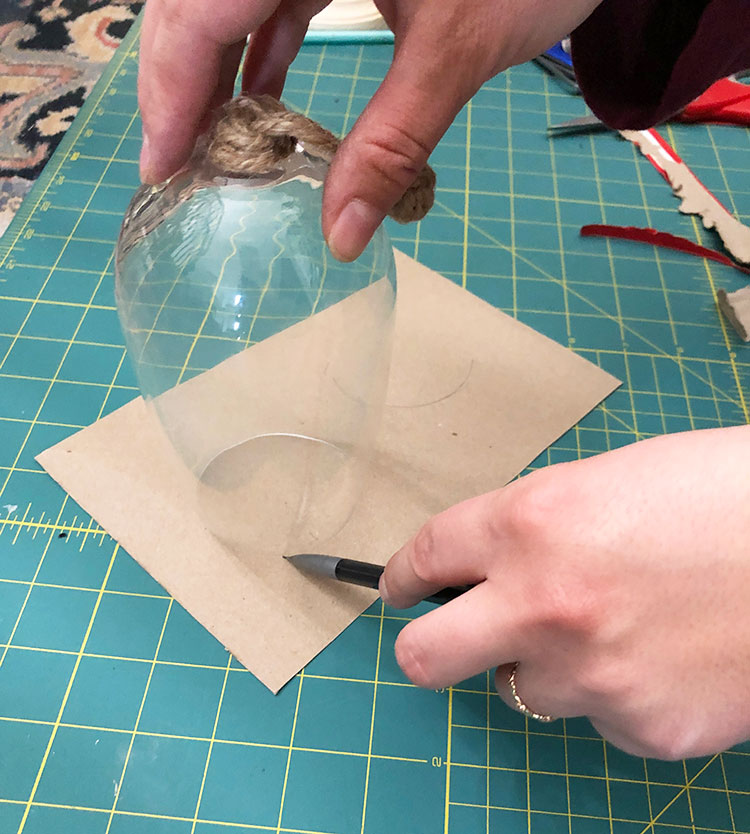 Tracing a circle onto cardboard for the wine glass cloche