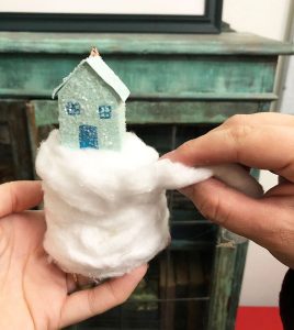 Homemade glitter house on a snowy hill of cotton balls
