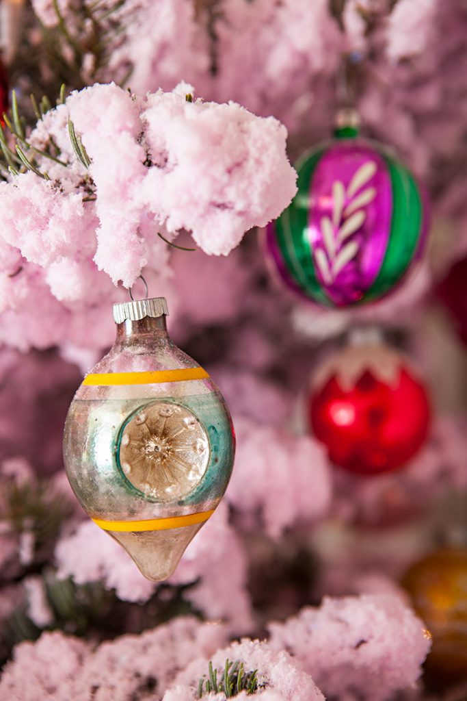 vintage ornaments hanging on a pink tree