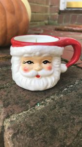 Santa mug filled with a white candle.
