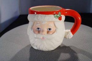 Santa mug with a sprig of holly on the side of his hat.