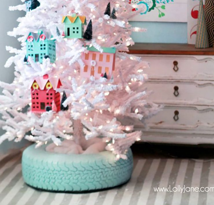 A Christmas tree stand cover in the shape of a turquoise-painted tire.