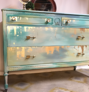 Cloudy blue and green painted dresser by CeCe Hunt with gold accents and arrow handles.