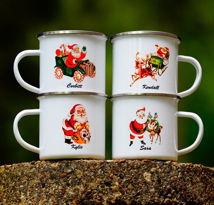Metal Santa mugs with different vintage-inspired illustrations of Santa and personalized names on them.