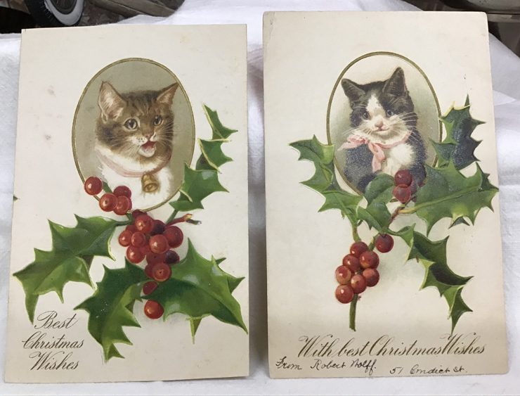 Two antique holiday postcards with cat portraits on them.