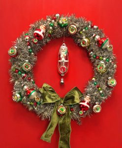Vintage Inspired tinsel wreath with Shiny Brite ornaments against a red background