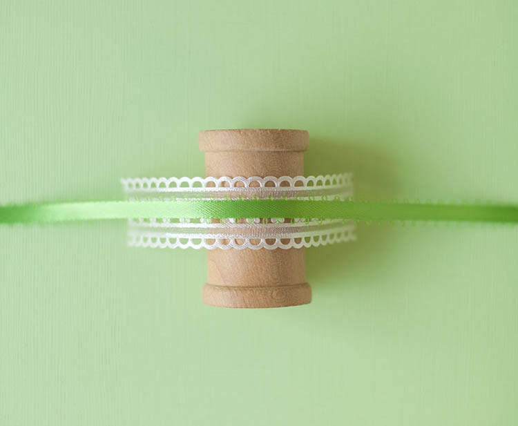 Step 2 of handmade craft tutorial, layering the trim over the wooden craft spool