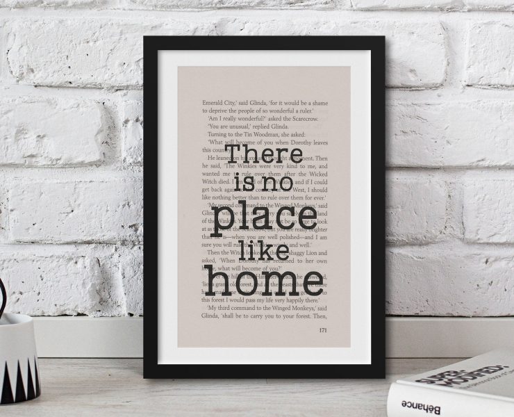 A framed book page with the quote "There is no place like home" written over it in typewriter font, a perfect gift for book lovers.
