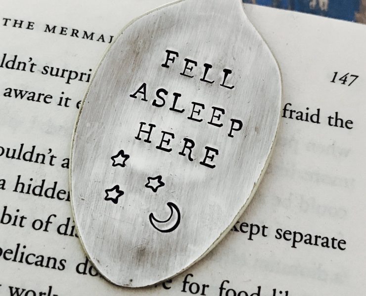 Flattened silver spoon turned into a clip-on bookmark that says "Fell Asleep Here" with moon and stars.