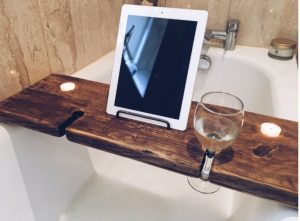 Wood bathtub tray with built-in spots for two wine glasses, two candles and a book or ipad.