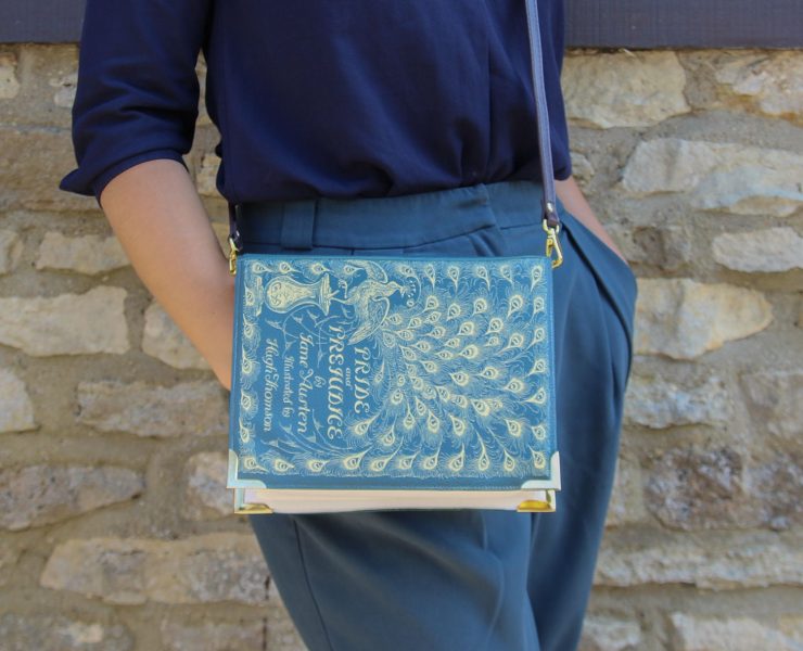 Cross-body purse with a blue and gold "Pride and Prejudice" book cover printed on the flip.