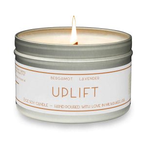 A candle that says "Uplift" on the label and smells like bergamot and lavender, one of our favorite gifts for new homeowners!