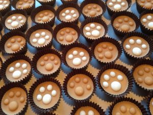 Peanut butter yogurt cups for dogs with paw print design, tasty gifts for pets.
