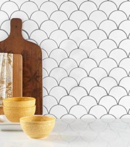 White backsplash tiles in the shape of fans.