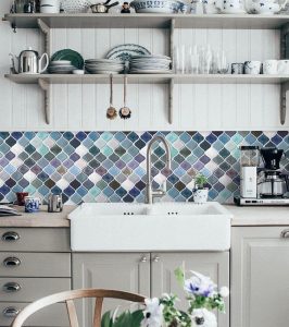 Blue and purple backsplash tiles in the shape of scales.