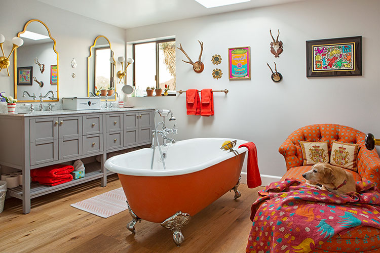 A vintage-inspired claw bathtub tinted a bright orange hue.
