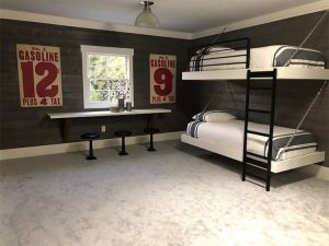 A children's room complete with vintage gasoline posters fashioned in red type and two bunk beds.