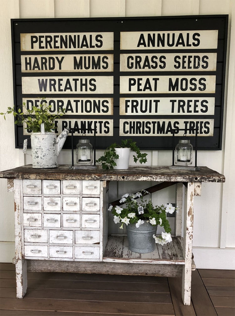 A vintage potter's cabinet with an array of farmhouse foliage and an antique metal signboard overhead as a part of the day in the life narrative.