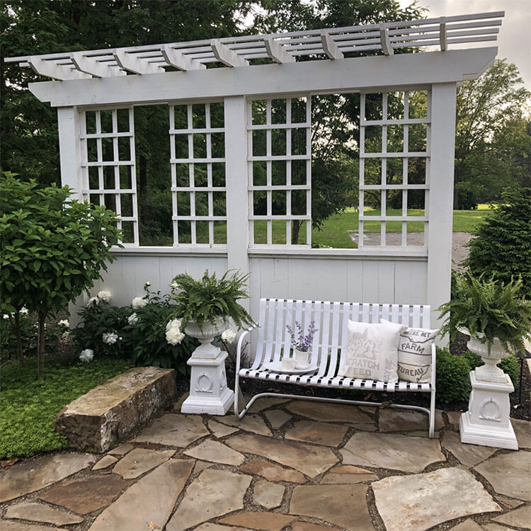 A white metal bench under a light-toned gazebo in relation to the day in the life story.