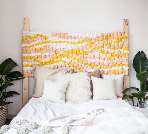 Woven headboards that is made of yellow, pink, and yellow wool yarn.