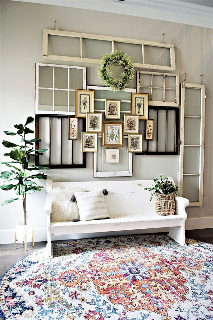 Vintage flower prints are layered over vintage windows for a vintage-inspired entryway.
