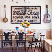 A rustic renovation featuring the dining room composed of antique signage and guitars.