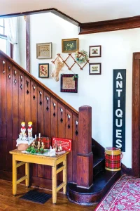 flea market figurines and tins on display at bottom of staircase in home featured in Santa Stoppers 2021 gallery