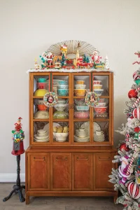hutch with vintage Pyrex and holiday vignette on top with Santa and reindeer