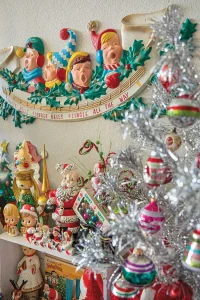 wall decor of singing children and shelves of vintage Santa angel and children figurines