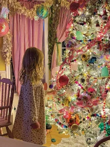 vintage color palette on Christmas tree with little girl in front of tree