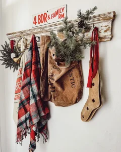 wall coat hanger with rustic holiday vignette with pine sprigs and plaid scarf