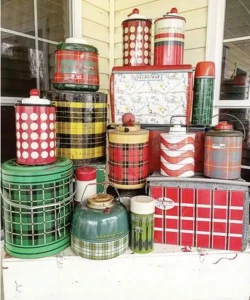 vintage lunch tins and thermoses in red and green form holiday vignette