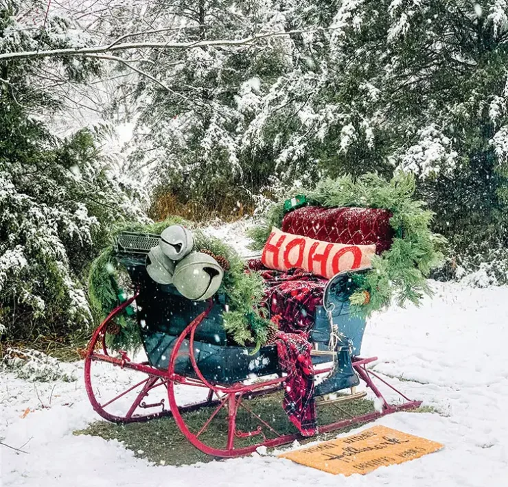 vintage sled with pine garlands and oversized bells in snowy landscape