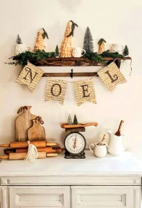 exposed kitchen shelf decorated for Christmas with handmade Noel banner using old sheet music