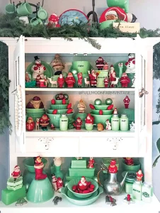 jadeite collection with small red Santa figurines and vintage style Christmas bulbs
