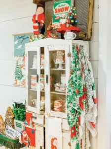 holiday flea market finds on display with cake stand, Santa mugs and linens in vintage patterns
