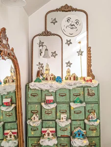 vintage apothecary cabinet as base for Christmas village
