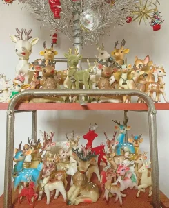 vintage reindeer figurine collection beneath tinsel tree