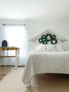 wreaths underneath architectural salvage used as art in bedroom in Santa Stoppers 2021 gallery