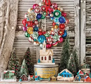 vintage Christmas village with bottlebrush trees and colorful ornament wreath