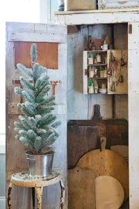 mini bottlebrush trees in small cups above a collection of vintage cutting boards