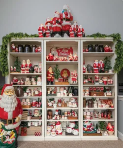 set of three shelves filled with Santa figurines and vintage Santa mugs
