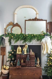 festive mantel with bells, bottlebrush trees and vintage mirrors