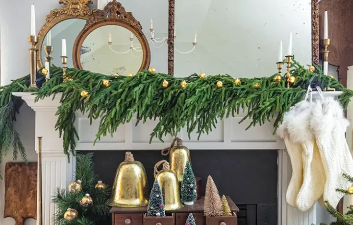 festive mantel with bells, bottlebrush trees and vintage mirrors