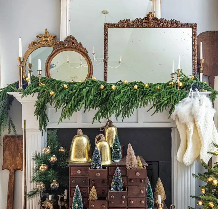 festive mantel with bells, bottlebrush trees and vintage mirrors